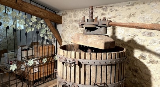 Ancien pressoir en bois dans une cave en pierre, utilisé pour presser le raisin dans la fabrication du vin.